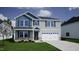 Two-story home with light gray siding, blue accent siding, and stone accents on the facade with green grass at 90 Cordoba Dr, Franklinton, NC 27525