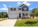 Charming two-story home with gray siding, blue accents, covered porch, and well-manicured lawn at 90 Cordoba Dr, Franklinton, NC 27525