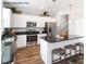 Modern kitchen featuring white cabinets, stainless steel appliances, a dark countertop island, and wood floors at 90 Cordoba Dr, Franklinton, NC 27525