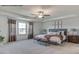 Spacious main bedroom featuring neutral decor, tray ceilings, a ceiling fan, and large windows with natural light at 90 Cordoba Dr, Franklinton, NC 27525
