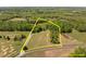 Aerial view of the property lines of the estate surrounded by green trees and pasture at 9400 Wheelers Church E Rd, Hurdle Mills, NC 27541