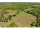 Aerial view of a home site including pond and pasture at 9400 Wheelers Church E Rd, Hurdle Mills, NC 27541