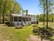 Large, level backyard with covered porch, stairs, picnic tables, seating, and a stone fire pit at 9400 Wheelers Church E Rd, Hurdle Mills, NC 27541