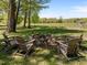 Charming backyard with stone fire pit and Adirondack chairs set on a grassy lot with trees in the background at 9400 Wheelers Church E Rd, Hurdle Mills, NC 27541