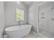 Sleek bathroom featuring a freestanding tub and a glass-enclosed shower with white subway tile and niche at 9400 Wheelers Church E Rd, Hurdle Mills, NC 27541
