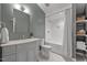 Well-lit bathroom featuring a vanity with marble countertop, a shower/tub combo, and built-in shelving at 9400 Wheelers Church E Rd, Hurdle Mills, NC 27541