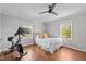 Bright bedroom featuring hardwood floors, a ceiling fan, and a stationary bike at 9400 Wheelers Church E Rd, Hurdle Mills, NC 27541