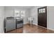 Well-lit laundry room featuring modern washer and dryer, a utility sink, and hardwood floors at 9400 Wheelers Church E Rd, Hurdle Mills, NC 27541