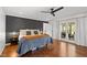 Stylish main bedroom with french doors, hardwood floors, a dark accent wall, and elegant decor at 9400 Wheelers Church E Rd, Hurdle Mills, NC 27541