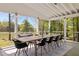 Bright screened porch with a large dining table and natural light streaming through the surrounding trees at 9400 Wheelers Church E Rd, Hurdle Mills, NC 27541
