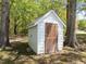 White, wooden storage shed with a dark brown door near some trees at 9400 Wheelers Church E Rd, Hurdle Mills, NC 27541