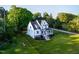 Expansive aerial view of a modern farmhouse with lush green lawn and mature trees at 1023 Laura Johnson Rd, Pittsboro, NC 27312