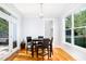 Dining area features a dark wood table, black chairs, and natural light from large windows at 1023 Laura Johnson Rd, Pittsboro, NC 27312