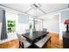 Dining room features a large dark wood table, seating, and natural light from the windows at 1023 Laura Johnson Rd, Pittsboro, NC 27312