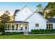 Charming white farmhouse with a covered porch and manicured landscaping at 1023 Laura Johnson Rd, Pittsboro, NC 27312