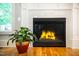 Close-up shot of a gas fireplace, accented by a potted plant and custom tile work at 1023 Laura Johnson Rd, Pittsboro, NC 27312