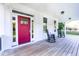 Charming front porch with rocking chairs, complemented by a vibrant red door and wood flooring at 1023 Laura Johnson Rd, Pittsboro, NC 27312