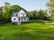 Attractive home with a covered porch set on a sprawling lawn with mature trees at 1023 Laura Johnson Rd, Pittsboro, NC 27312