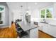Modern kitchen with white cabinetry, island with bar seating, and stainless steel appliances, and wood floors at 1023 Laura Johnson Rd, Pittsboro, NC 27312