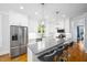 A modern kitchen features an island with seating, stainless steel appliances, and white cabinetry at 1023 Laura Johnson Rd, Pittsboro, NC 27312