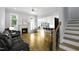 Cozy living room with a white mantel fireplace, hardwood floors, and natural light from the large windows at 1023 Laura Johnson Rd, Pittsboro, NC 27312