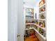 Walk-in pantry with built-in shelving filled with various food items and a wood floor at 1023 Laura Johnson Rd, Pittsboro, NC 27312