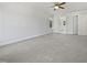 Bright bedroom featuring neutral carpeting, ceiling fan, and a glimpse into the adjacent bathroom through the doorway at 103 Loch Ryan Way, Cary, NC 27513
