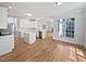 Bright kitchen open to the living area, featuring white cabinets and hardwood floors at 103 Loch Ryan Way, Cary, NC 27513
