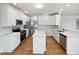 Well-lit kitchen with white cabinets, stainless steel appliances, and hardwood floors at 103 Loch Ryan Way, Cary, NC 27513