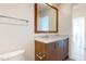 Bathroom featuring a wood vanity with chrome fixtures, marble countertops, and a decorative mirror at 110 N Corcoran St # 2101, Durham, NC 27701