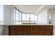 Kitchen island features wood cabinets, stainless sink, and large windows with expansive city views at 110 N Corcoran St # 2101, Durham, NC 27701