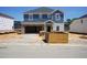 Two-story home featuring a brick-accented garage and charming blue and white siding, awaiting landscaping at 1113 Landen Creek Ln, Zebulon, NC 27597