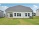 Rear view of home shows a covered patio, large lawn, and white siding at 1121 Landen Creek Ln, Zebulon, NC 27597