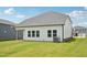 Rear view of home shows a covered patio, large lawn, and white siding at 1121 Landen Creek Ln, Zebulon, NC 27597