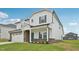 Side view of a charming two-story home with a white facade, brick accents, and a spacious two-car garage at 1121 Landen Creek Ln, Zebulon, NC 27597