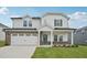 Charming two-story home with a white facade, brick accents, and a spacious two-car garage at 1121 Landen Creek Ln, Zebulon, NC 27597