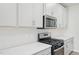 Close-up of a modern kitchen stove, microwave, quartz countertops, and white herringbone backsplash at 1121 Landen Creek Ln, Zebulon, NC 27597