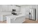 Modern kitchen featuring white cabinets, stainless steel appliances, and a spacious quartz island at 1121 Landen Creek Ln, Zebulon, NC 27597