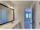 Well-lit bathroom with a large mirror, vanity with a sink, and a view into an adjacent carpeted bedroom at 113 Union Mills Way, Cary, NC 27519
