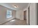 A clean, carpeted bedroom features a window with natural light and a closet for storage at 113 Union Mills Way, Cary, NC 27519