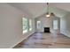 Bright living room featuring a vaulted ceiling, a cozy fireplace, and hardwood floors, enhanced by natural light from large windows at 113 Union Mills Way, Cary, NC 27519