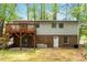 Two-story house with light siding, a deck, brick foundation, and access to the backyard, nestled among mature trees at 1209 Shincliffe Ct, Cary, NC 27511