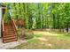 The backyard offers a private deck, a well-manicured lawn, mature trees, and a wooden fence creating a secluded outdoor space at 1209 Shincliffe Ct, Cary, NC 27511