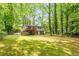 Spacious backyard featuring a lush green lawn, mature trees offering shade, and a serene setting for outdoor enjoyment at 1209 Shincliffe Ct, Cary, NC 27511