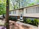 Charming two-story home with a brick foundation, light siding, mature trees, and lush greenery in the front yard at 1209 Shincliffe Ct, Cary, NC 27511