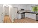 Updated kitchen with modern appliances, white cabinets, wood floor and bright lighting, offering a clean and functional space at 1209 Shincliffe Ct, Cary, NC 27511