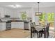 Bright kitchen features white cabinets, stainless steel appliances and a dining area with a door to the deck at 1209 Shincliffe Ct, Cary, NC 27511