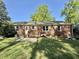View of the backyard showing the brick home and stone patio perfect for outdoor enjoyment at 131 Rosewood Dr Dr, Roxboro, NC 27573