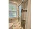 Bathroom featuring marble tile flooring, window, and a shower with glass door at 131 Rosewood Dr Dr, Roxboro, NC 27573