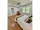 Relaxing bedroom with a ceiling fan, window views, artwork, hardwood floors, and a sitting chair at 131 Rosewood Dr Dr, Roxboro, NC 27573